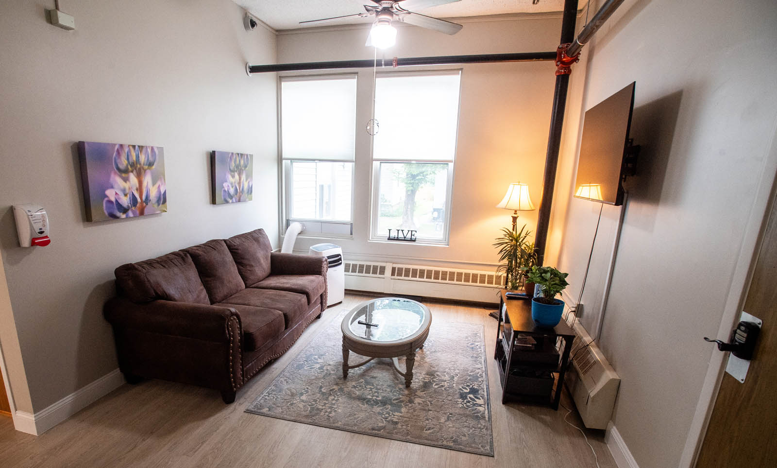 A lounge area with a couch and a TV in the Wellstone Center for Recovery.