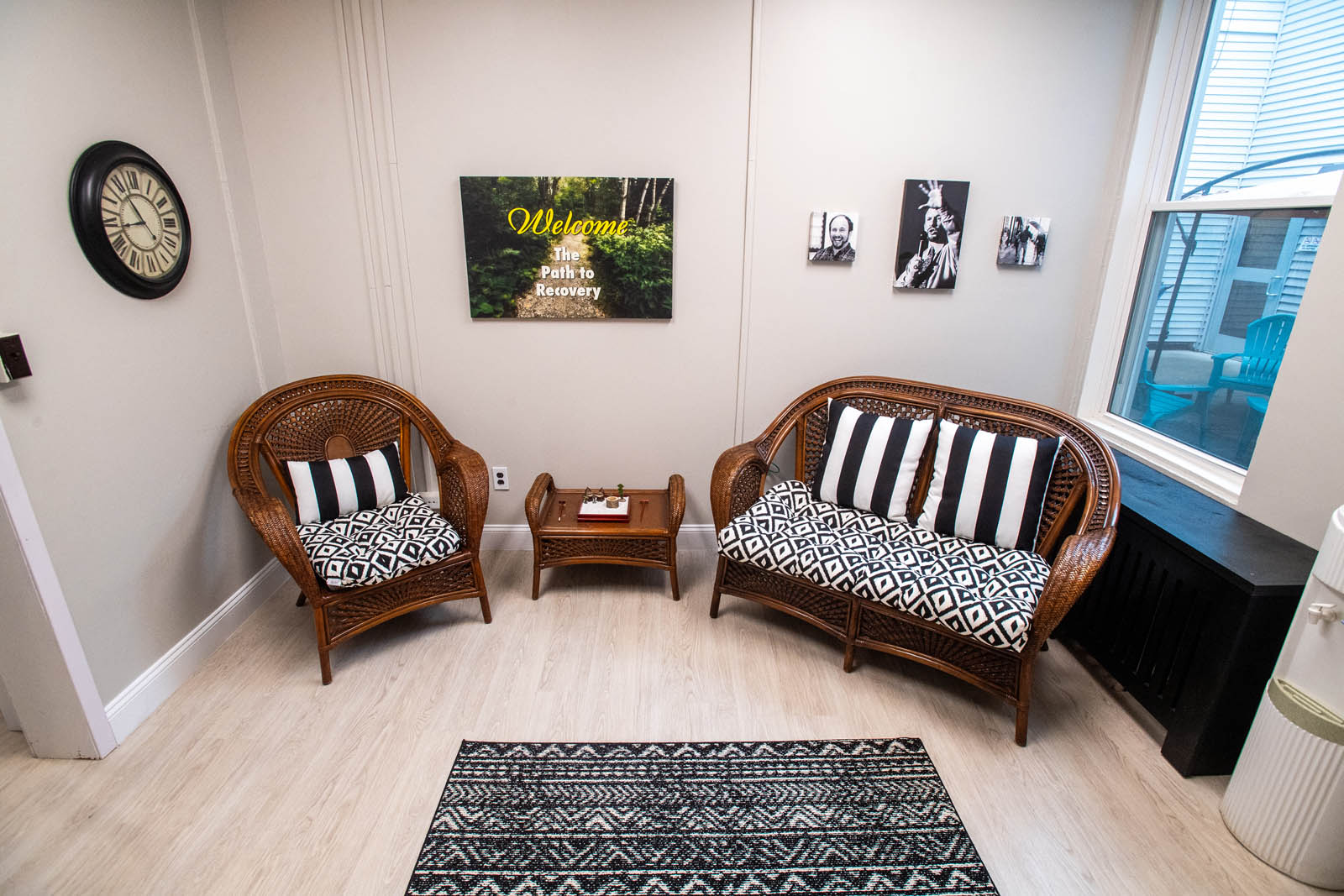 A waiting area with inspirational pictures on the wall along with two chairs.